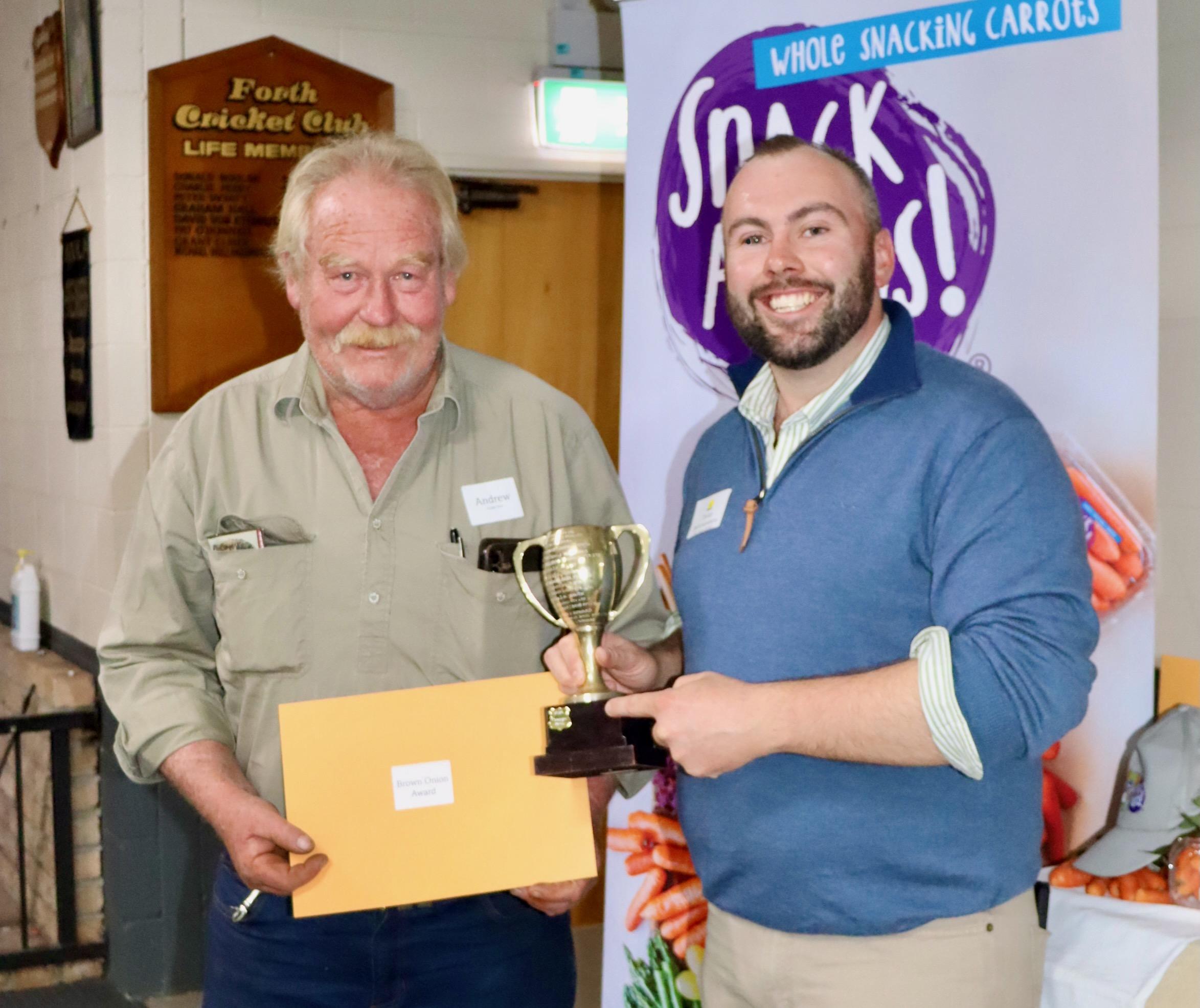 Andrew Craigie accepts the Excellence in Agriculture award  from field officer Dylan Bellchambers.