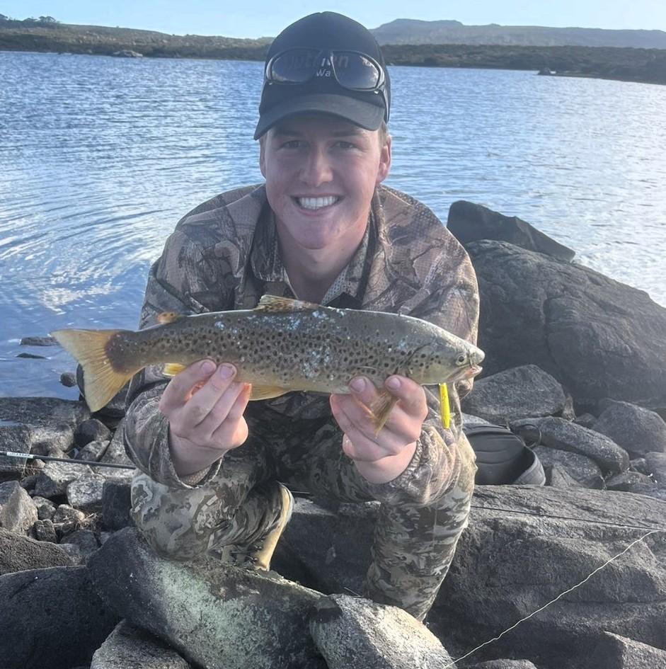 Benjamin Atkins with a nice brown trout he caught from Great Lake