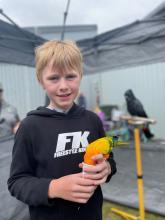Jaylan Pullen, 10 of Forest feeds one of the Majick Featurers parrots