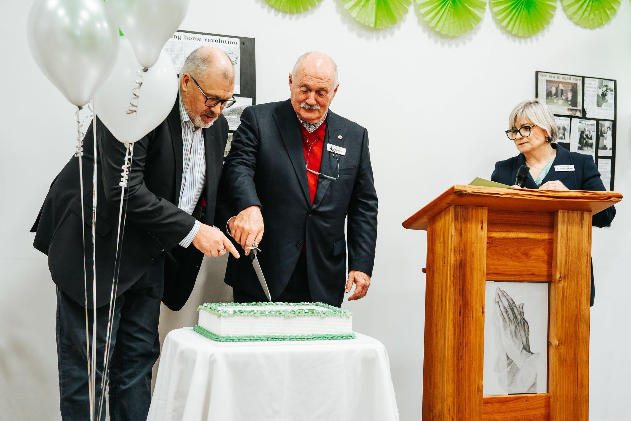 MLC Craig Farrell and Corumbene President and Chair of the Board of Management, Ross Carlyle.cutting the 60th Birthday cake watched on by Corumbene CEO Alison Standen. 
