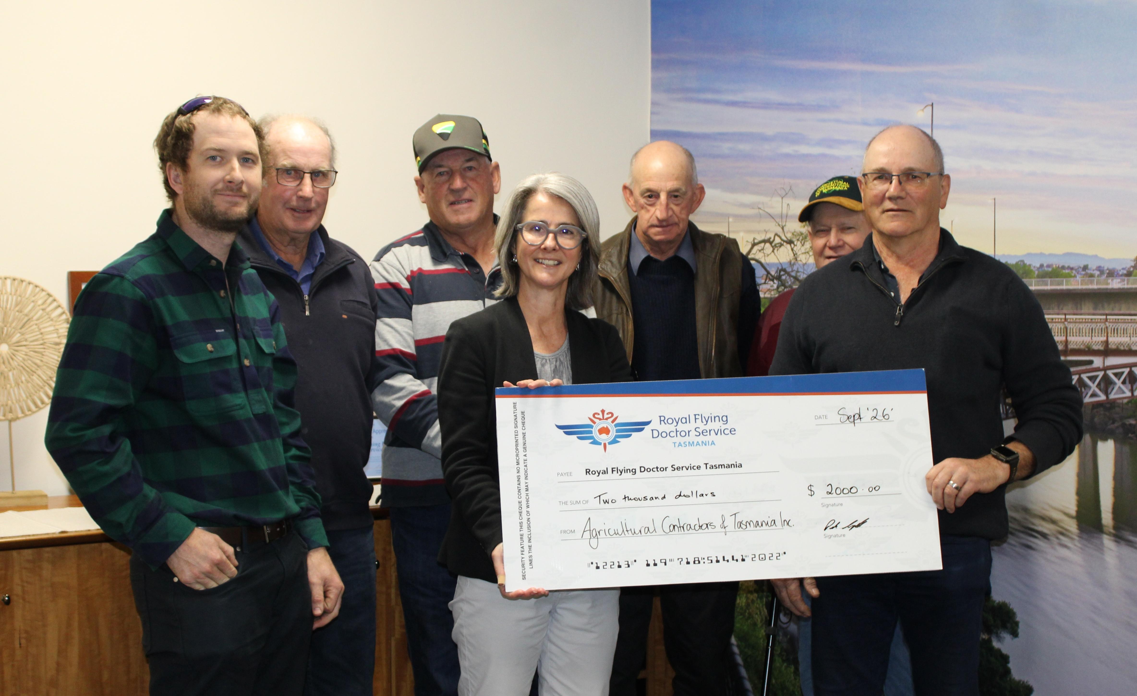 Agricultural Contractors of Tasmania Inc members Daniel French, Ivan French, Roger Fish, Glen McInnes, Phillip Boyd and president Peter Campbell present RFDS Tasmania CEO Nicole Henty with a cheque for $2000.