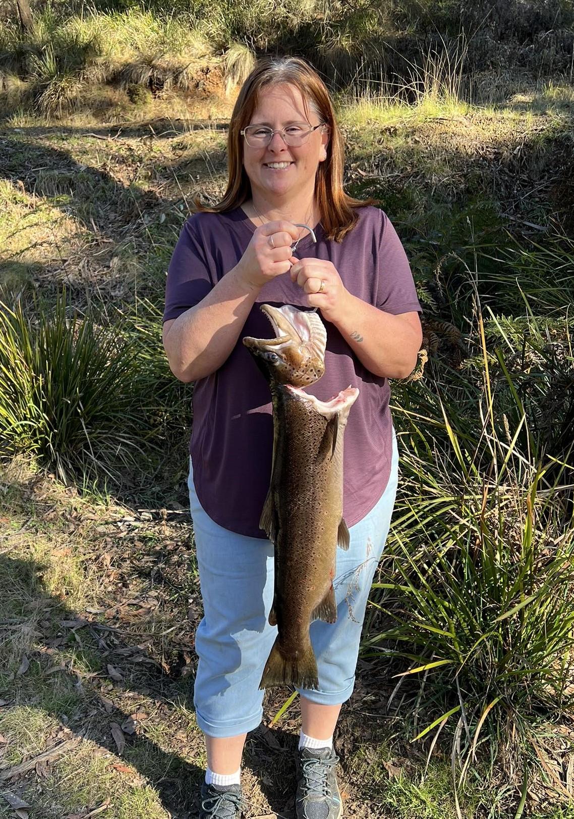 Kylie Price with the 2.9 kg or 6.6 lb brown trout she caught from the Huon River.