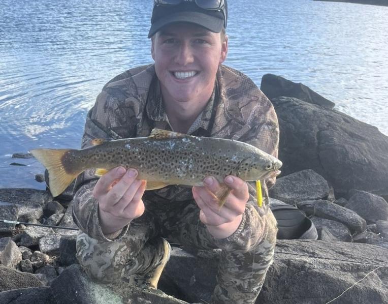 Benjamin Atkins with a nice brown trout he caught from Great Lake