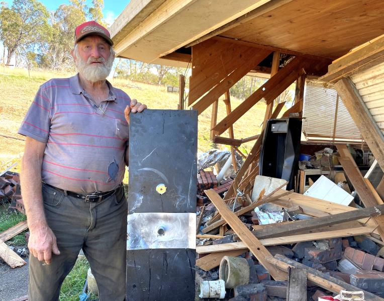 Whitemore sheep farmer David Lindsay with the door of his gun safe (in the background) that was prised off when thieves destroyed his garage and stole his rifle.