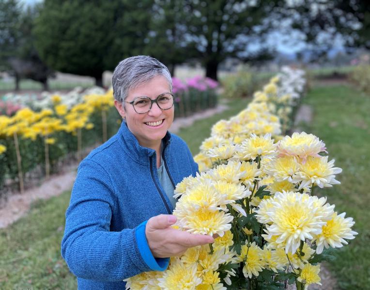 Donna Tracey with the  chrysanthemums that flourish on the  couple’s property.