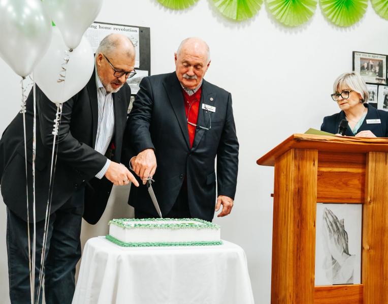 MLC Craig Farrell and Corumbene President and Chair of the Board of Management, Ross Carlyle.cutting the 60th Birthday cake watched on by Corumbene CEO Alison Standen. 