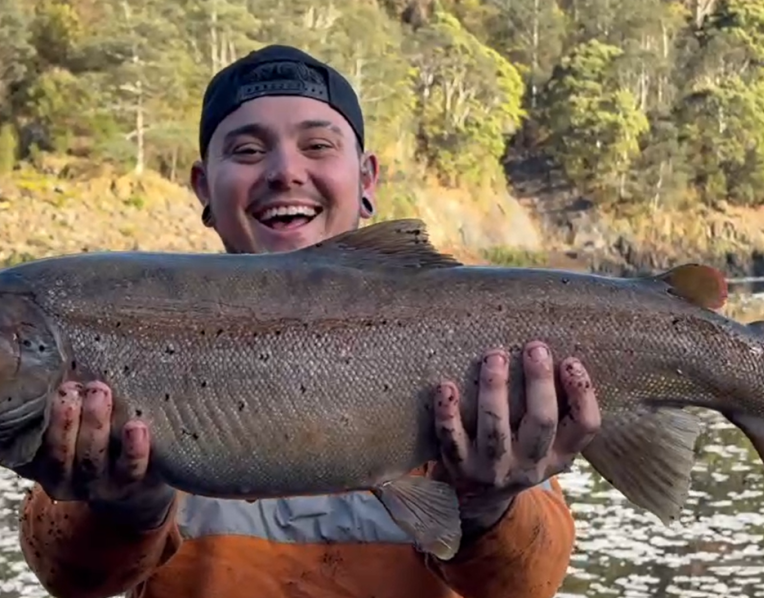 Kade Wall with the magnificent female brown trout he caught and released in the Pieman River.