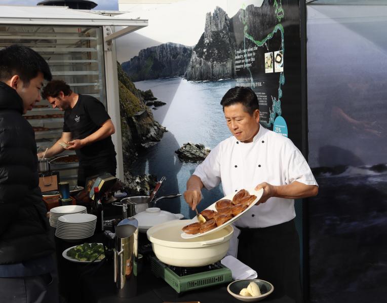 Seafood buyers watching abalone being prepared