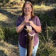Kylie Price with the 2.9 kg or 6.6 lb brown trout she caught from the Huon River.