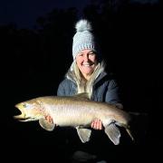 Tammy Darwin with the monster female brown trout she caught from the Huon River last weekend