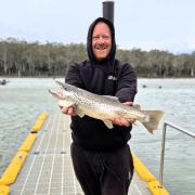 Justin Stevens with a solid male brown trout he caught spinning off the jetty at Lake Leake last weekend.
