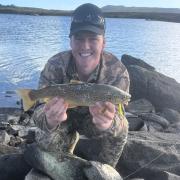 Benjamin Atkins with a nice brown trout he caught from Great Lake