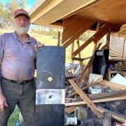 Whitemore sheep farmer David Lindsay with the door of his gun safe (in the background) that was prised off when thieves destroyed his garage and stole his rifle.