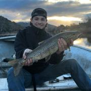 Mitchell Kaititis with a solid brown trout he caught from the Derwent River recently
