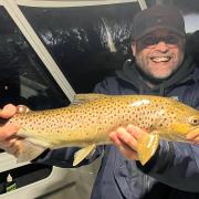 Adam Williams with a trout caught recently in the Derwent River.